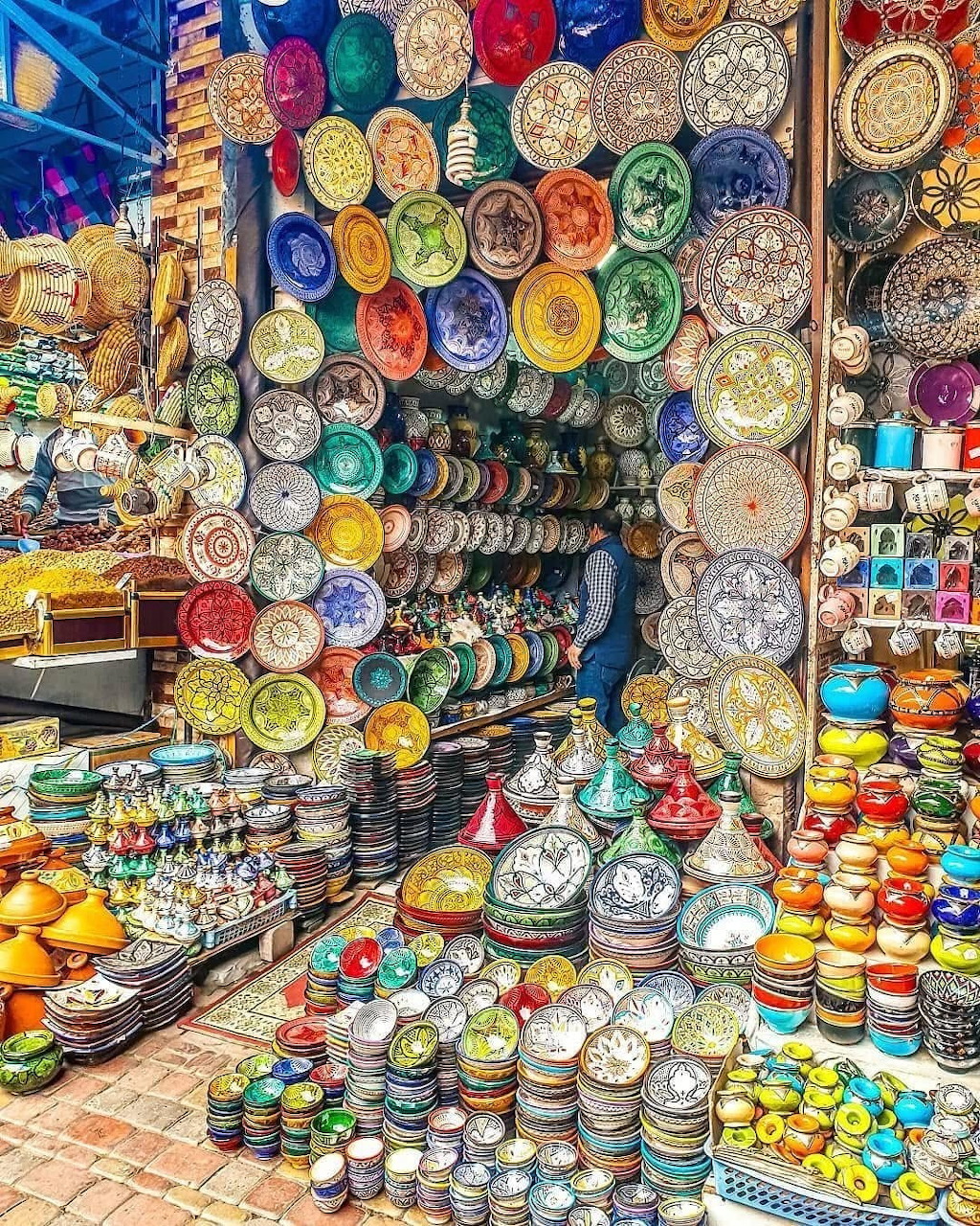 Colorful display of traditional Moroccan ceramic plates and pottery at a market stall