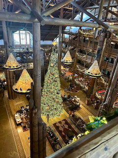 Rustic lodge lobby with tall Christmas tree and wooden beams
