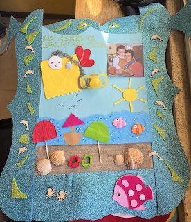 Handmade glitter picture frame with beach-themed decorations including seashells, felt fish, and a family photo