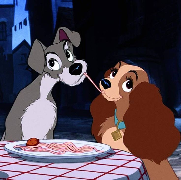 Lady and Tramp dogs sharing a strand of spaghetti at a table