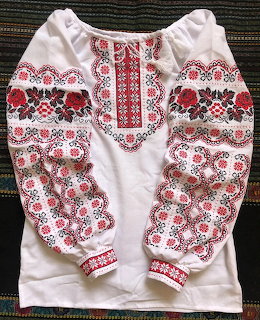 White Ukrainian vyshyvanka blouse with detailed red and black cross-stitch embroidery patterns