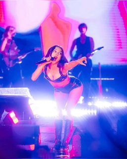 Olivia Rodrigo in festival outfit performing on stage