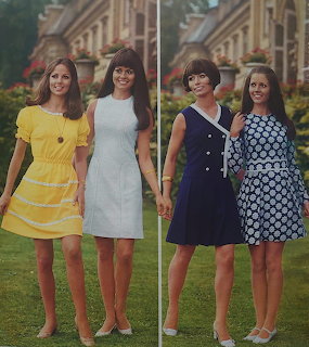 Four women in colorful vintage spring dresses posing outdoors in front of a garden and mansion