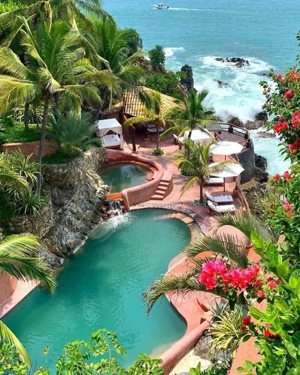 Tropical resort pools with palm trees and ocean view in Mexico