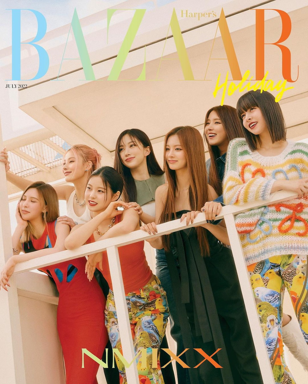 NMIXX members posing on a balcony for Harper's Bazaar magazine cover in colorful outfits
