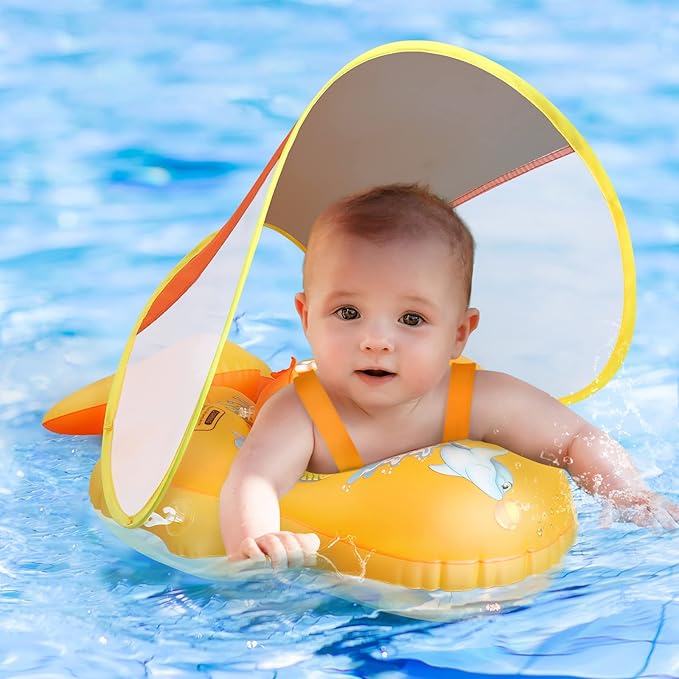 Baby in yellow inflatable swim float with canopy in blue pool water
