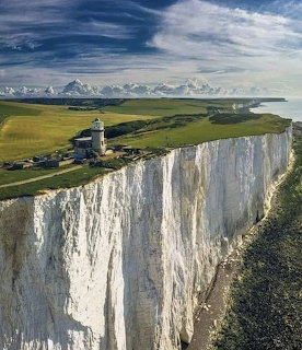 White Cliffs of Dover with lighthouse on green clifftop and dramatic cloudy sky