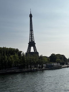 Eiffel Tower viewed from across the Seine River in Paris, surrounded by trees