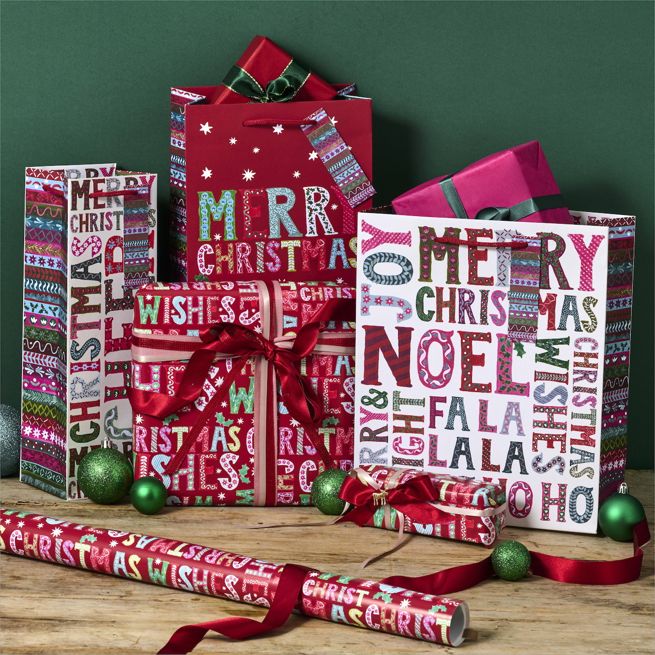 Colorful Christmas gift bags and wrapped presents with festive holiday patterns and text on green background