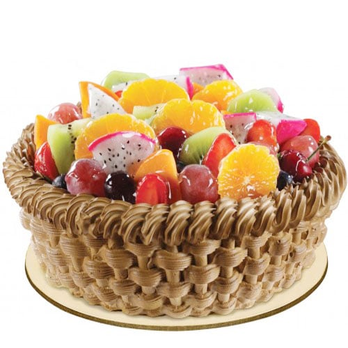 Fruit-topped cake with basket-weave frosting on a white background