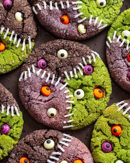 Chocolate cookies decorated as Halloween monsters with green icing, candy eyes, and zigzag white icing teeth