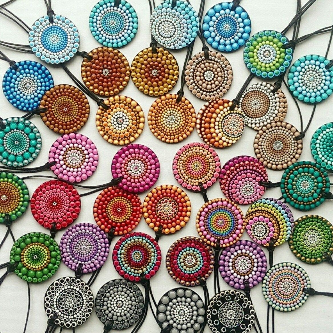 Assortment of circular mandala pendants with detailed dot patterns in various colors