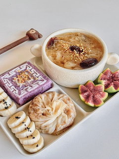 Overhead dessert board with crème brûlée, figs, pastries, and chocolates on white marble