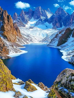 Alpine lake surrounded by snowy mountain peaks in Glacier National Park