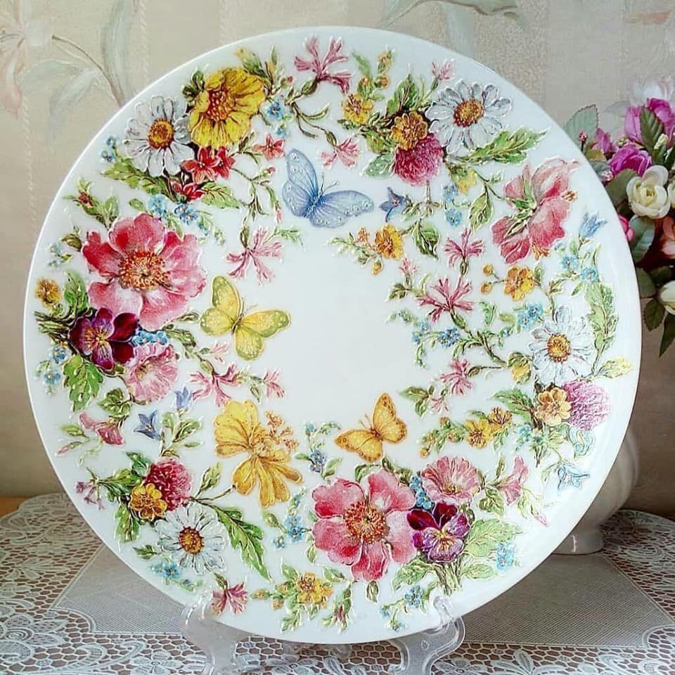 Vintage decorative plate with floral wreath and butterfly pattern on white background