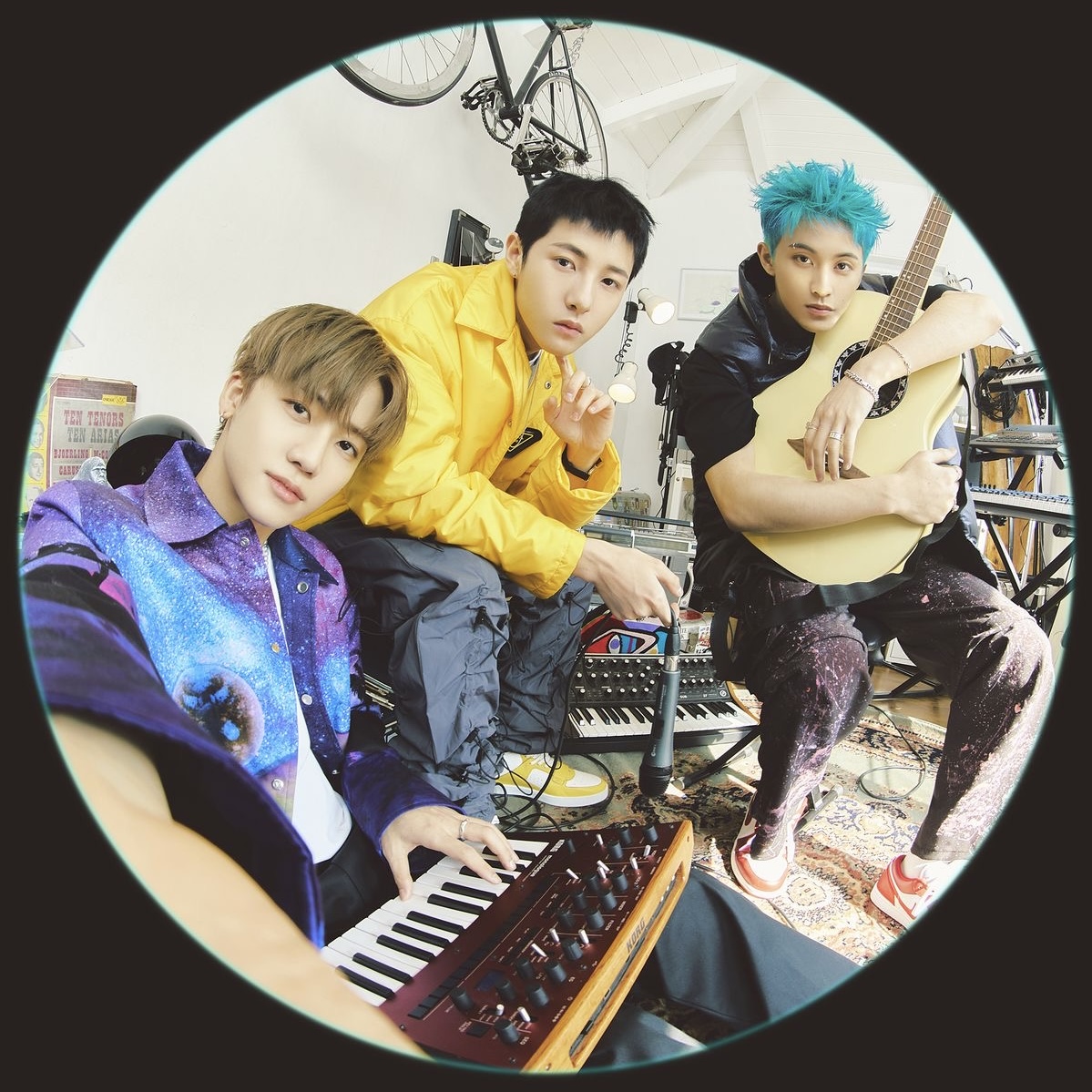 Three young men posing in a music studio with instruments including keyboard and guitar in circular crop
