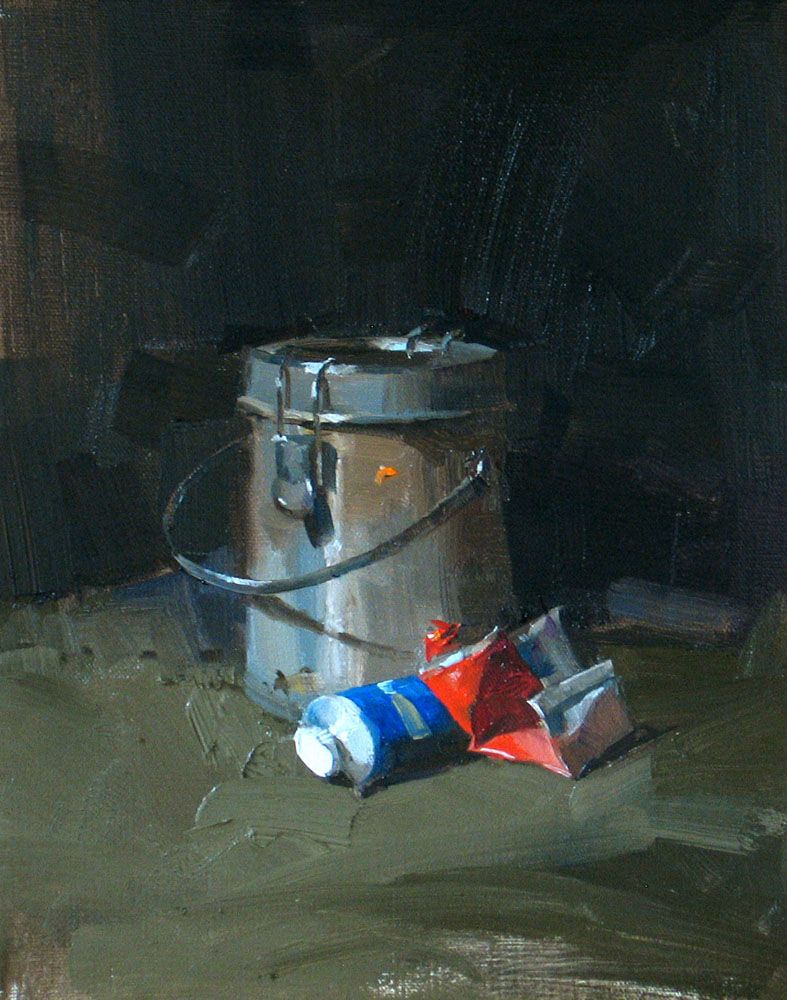 Metal paint can and red and blue paint tubes in a dark studio still life.