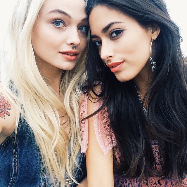 Two young women with blonde and dark hair posing together for portrait photo