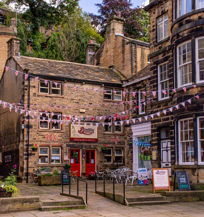 Stone buildings with bunting and red doors in a quaint Yorkshire courtyard