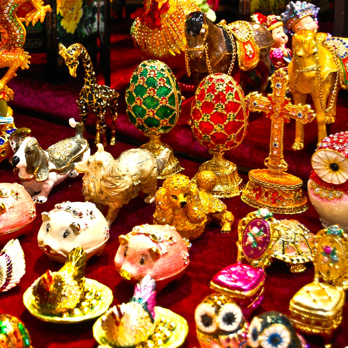 Collection of ornate jeweled decorative eggs and gilded trinkets with enamel patterns and gemstones