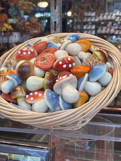 Wicker basket filled with colorful ceramic mushroom figurines in a shop display