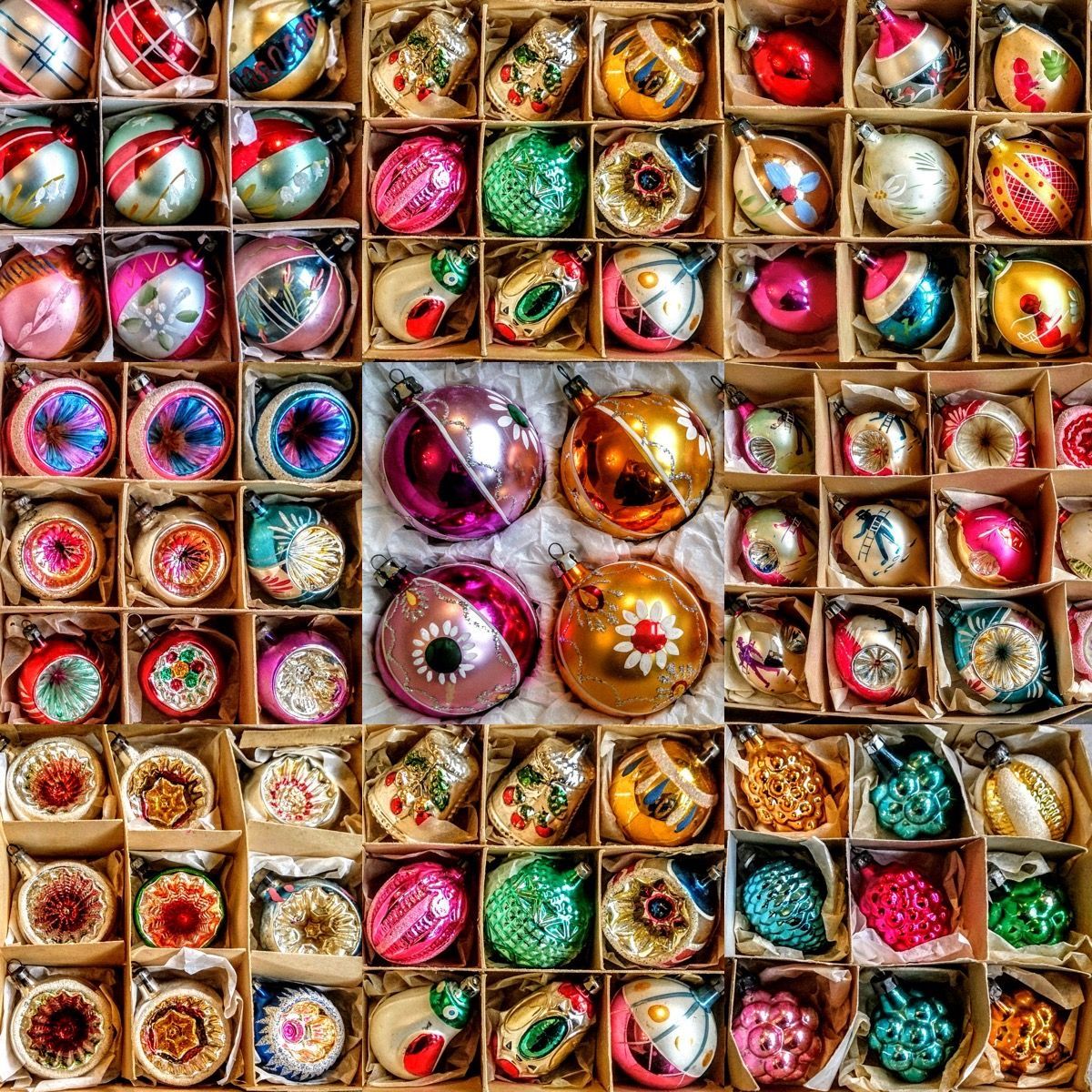 Collection of vintage glass Christmas ornaments in red, gold, green, pink, and silver arranged in compartments