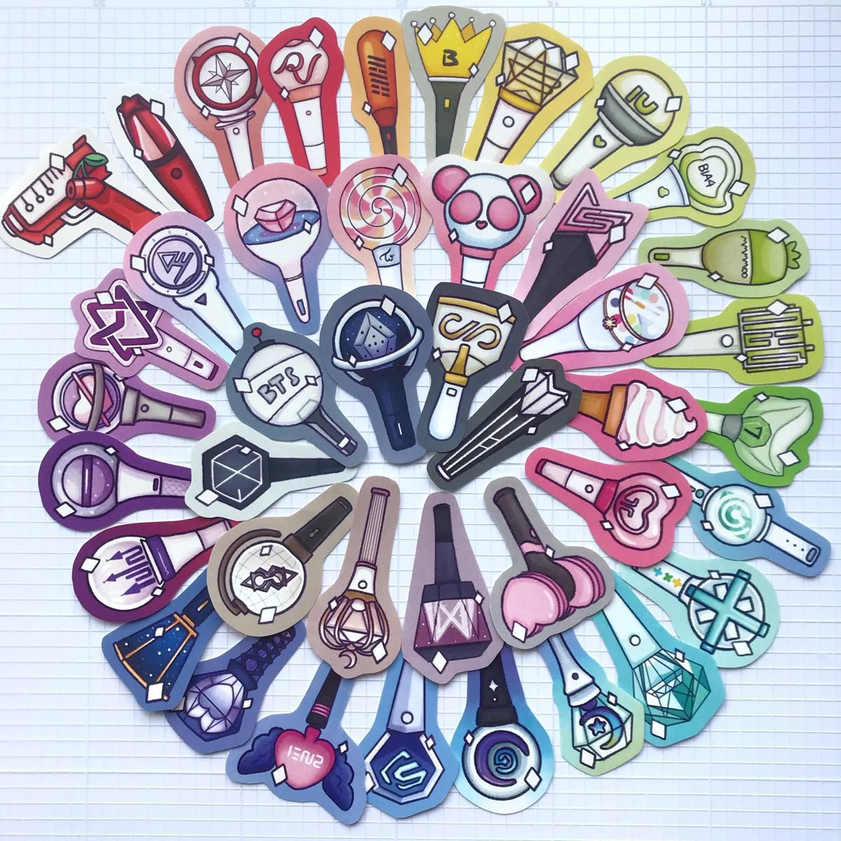 Illustrated K-pop lightsticks in many colors arranged in a circular pattern on a light grid background
