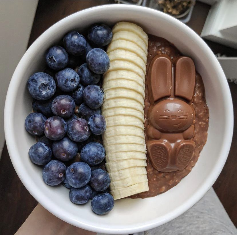 Bowl of chocolate oatmeal with blueberries, banana slices, and a chocolate bunny on top