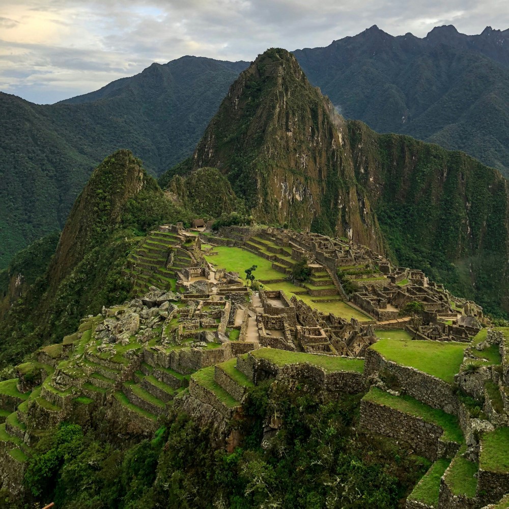 Machu Picchu ruins with green terraces and steep mountains in Peru