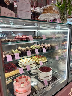 Glass bakery display case with assorted decorated cakes and pastries