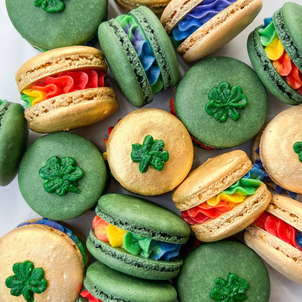 Green and tan macarons with shamrock decorations and rainbow fillings