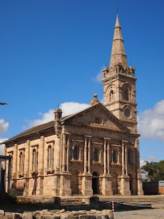 Stone chapel with tall bell tower and neoclassical facade in Antananarivo