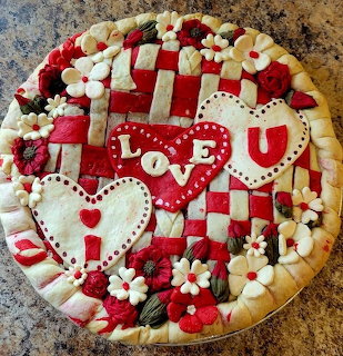Valentine pie decorated with heart cookies, flowers, and red-and-white lattice icing