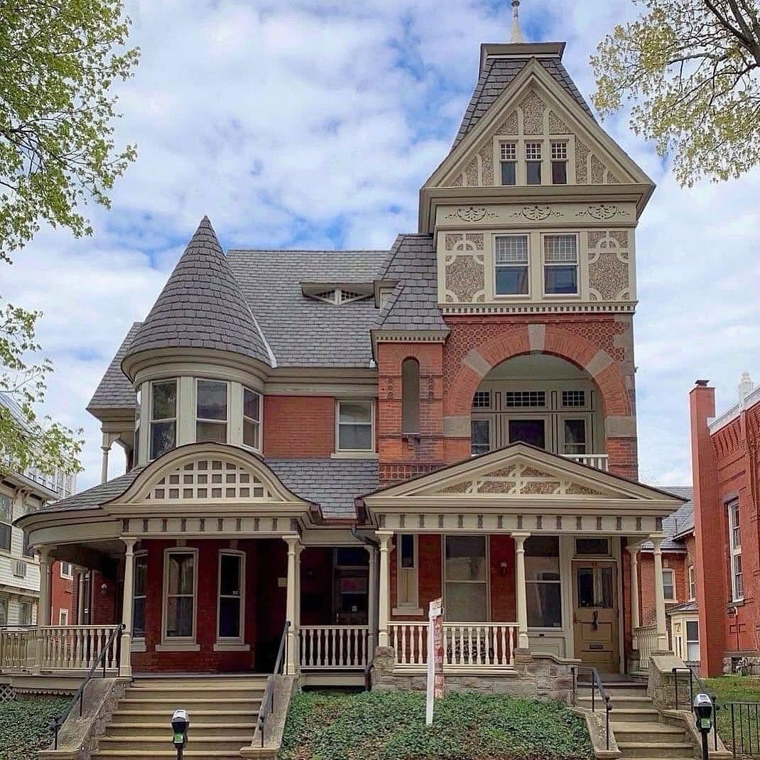 Victorian house with turret, stone details, and wraparound porch