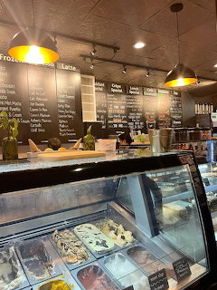 Cafe interior with chalkboard menus, yellow pendant lights, and gelato display case