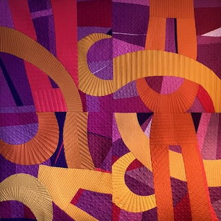 Abstract quilt with orange curved strips over purple and pink geometric patchwork