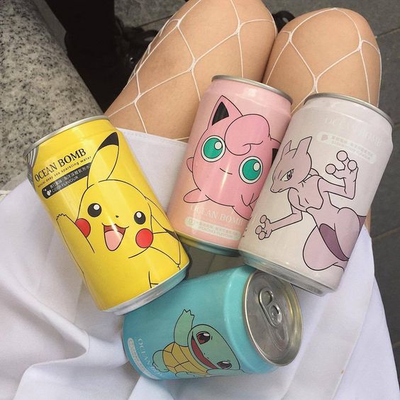 Four Pokémon-themed soda cans on white plate with Pikachu, Jigglypuff, Mew, and Squirtle designs