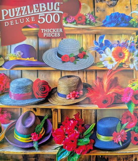 Decorative hats with flowers and ribbons arranged on wooden shelves