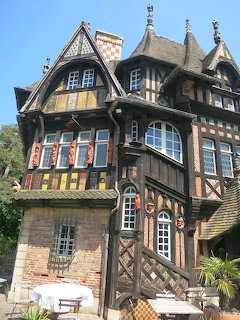 Ornate gothic half-timbered building with colorful tiles and pointed gables in Normandy
