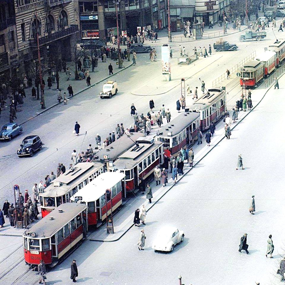Aerial view of vintage trams and pedestrians on 1950s Prague street