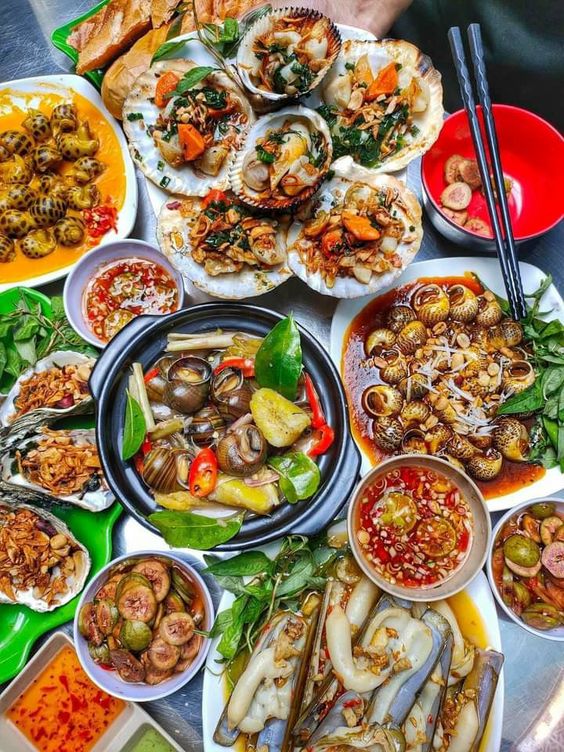 Top-down view of various Asian dishes arranged on a table with chopsticks and colorful bowls