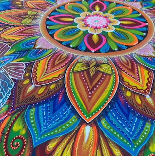 Colorful mandala with rainbow petals and geometric patterns radiating from floral center