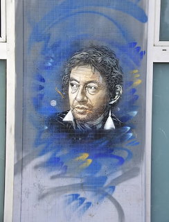 Mixed media portrait of a man with blue abstract brushstrokes on textured background