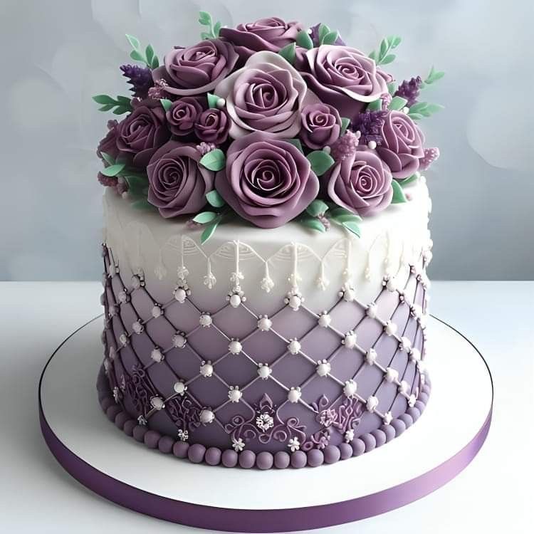 Two-tier purple and white cake topped with decorative purple fondant roses