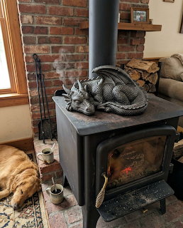 Stone dragon statue on a black wood stove with a golden dog sleeping beside it in a cozy room
