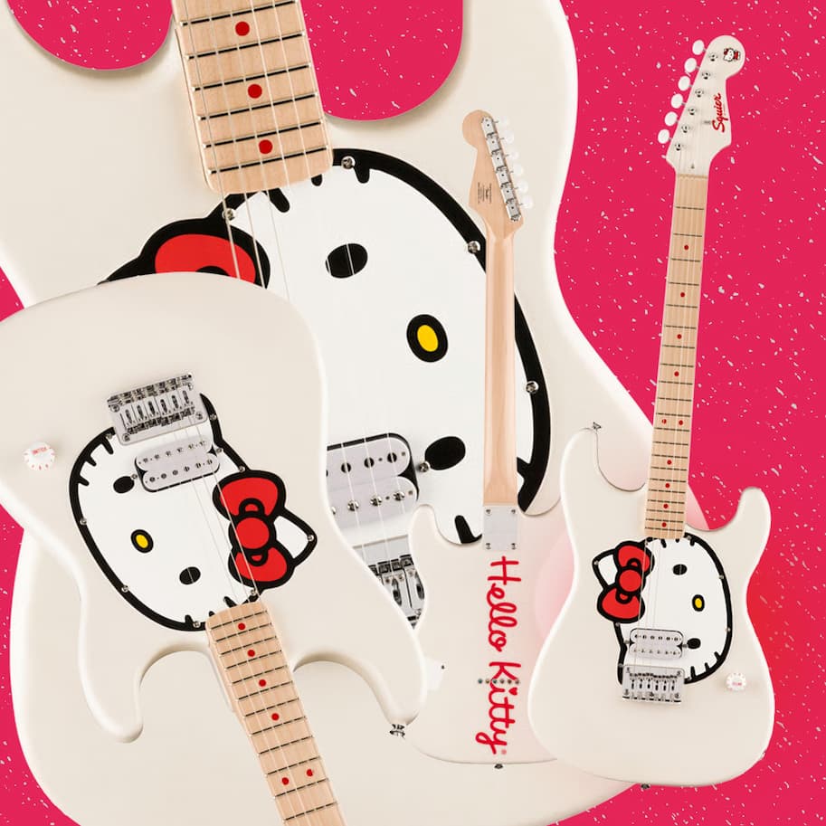 Three white Hello Kitty electric guitars with pink glitter accents on a pink background