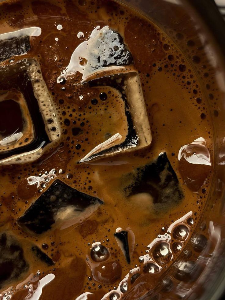 Overhead view of iced coffee with vanilla ice cream scoop and ice cubes in glass