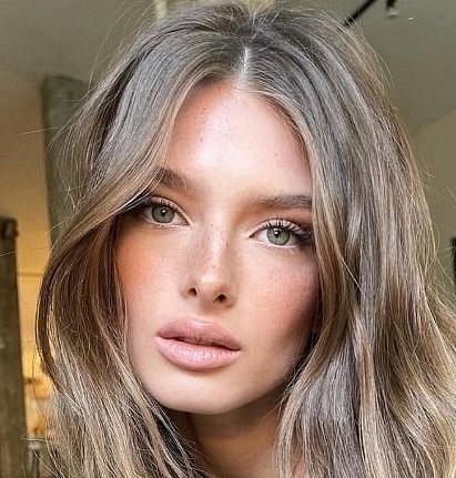 Close-up portrait of a young woman with ash blonde hair and green eyes