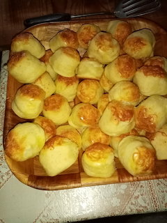 Tray of golden baked cheese scones with browned tops on a wooden surface