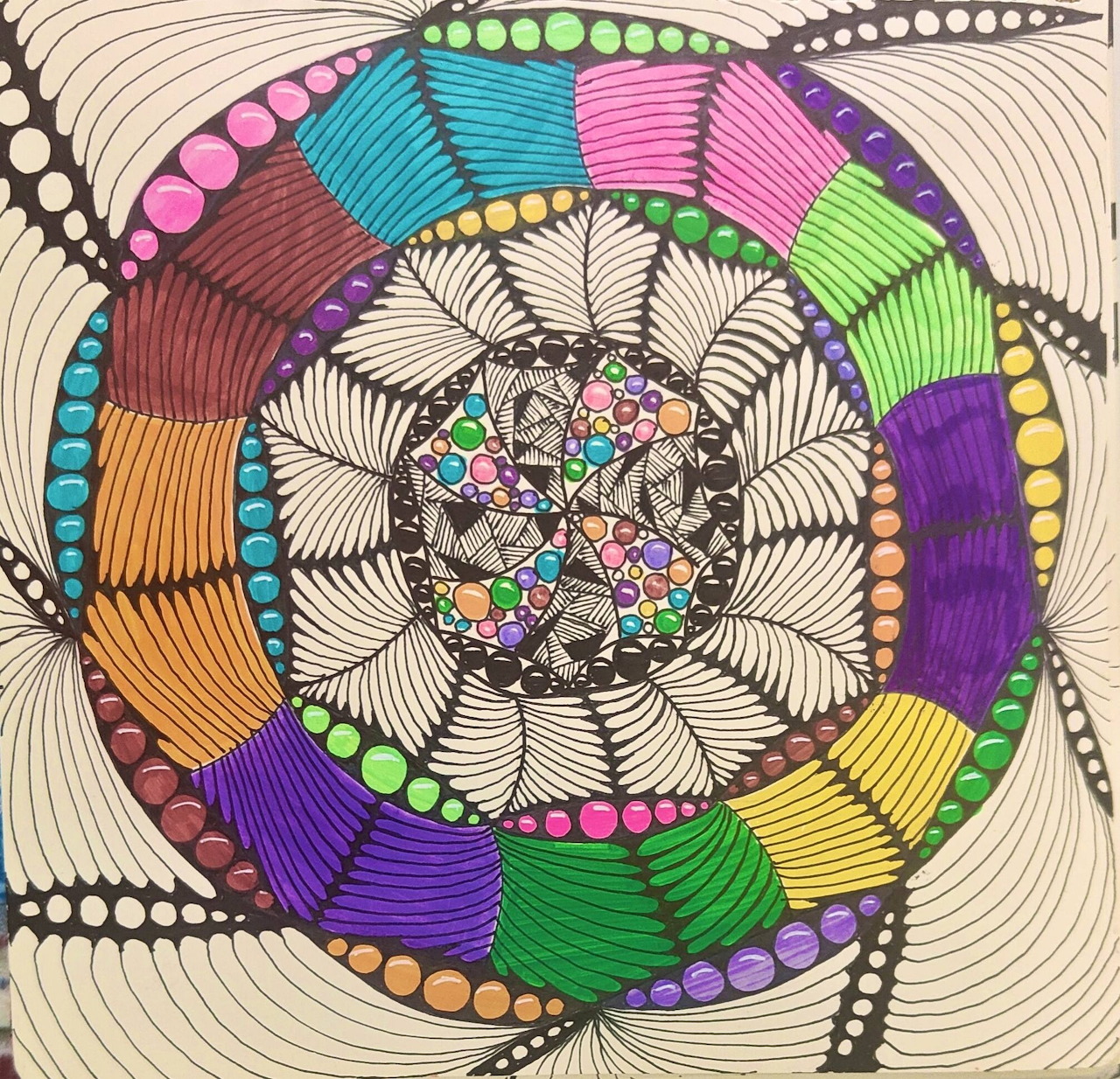 Hand-drawn mandala with rainbow colored petals and zentangle patterns